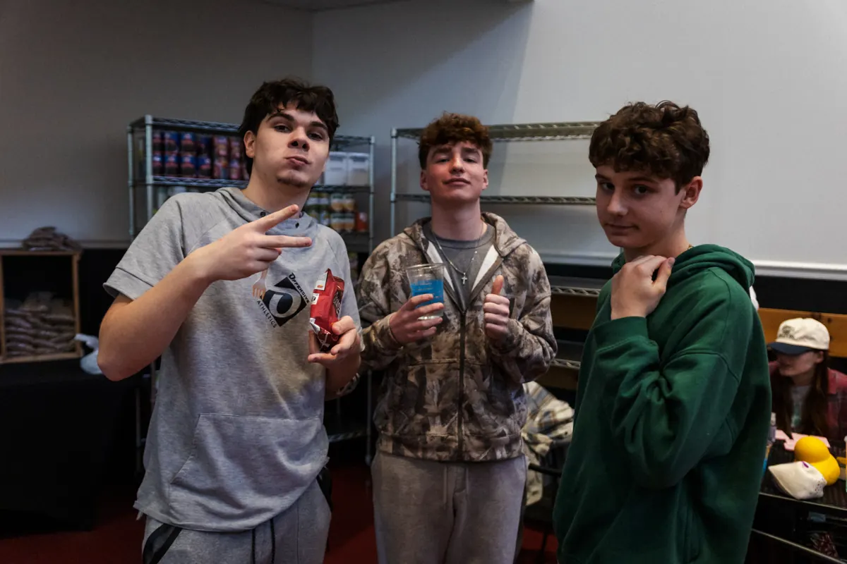 Three students hanging out and laughing at youth night